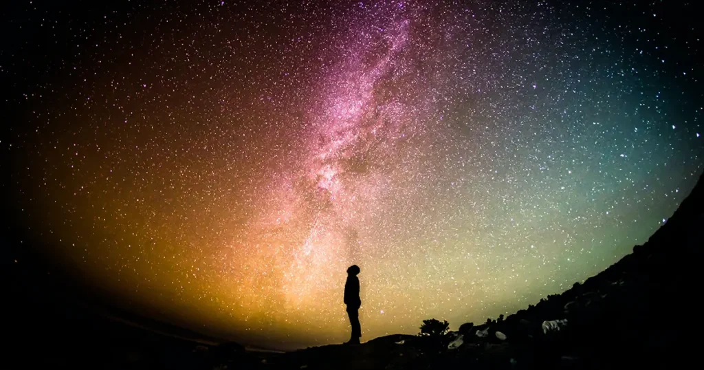 Person looking up at the stars in a night sky for #designtips article Why your business needs a website​